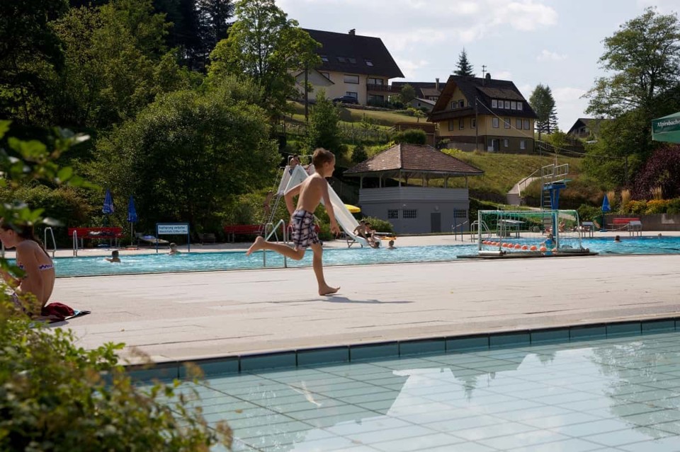 Ein Junge rennt zwischen dem Schwimmerbecken und dem Baybecken im Freibad Klosterreichenbach.