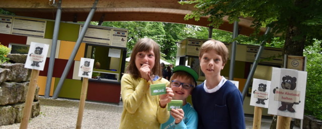 Drei Kinder stehen vor dem Eingang des Freizeitparks Traumland und halten die AlbCard in der Hand.