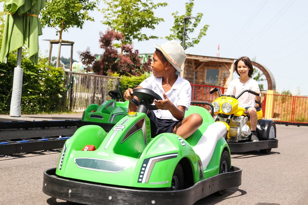 Zwie Kinder fahren mit E-Karts auf der E-Kartbahn der KLIMA ARENA.